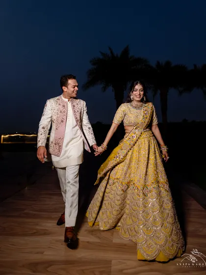 Walking hand-in-hand into their future. This shot captures the beautiful movement of their coordinated engagement outfits, designed for a stylish and comfortable evening.