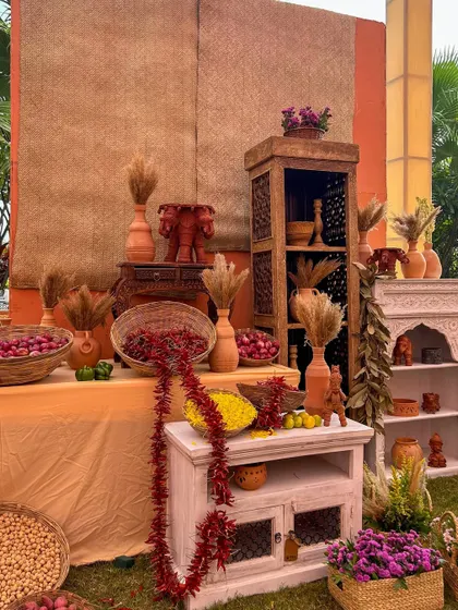 A display of rustic wooden and whitewashed furniture, decorated with spices, flowers, and terracotta elephants, contributing to the eclectic charm of the bazaar.
