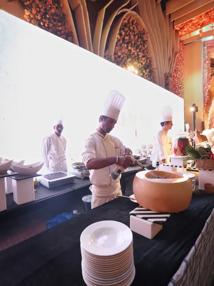 A chef at our live pasta station, working over a large wheel of Parmesan cheese. This classic preparation method is a spectacle in itself and guarantees a rich, authentic flavour.
