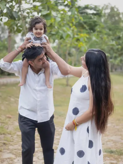 A playful moment with dad lifting his son onto his shoulders while mom looks on. These are the candid memories we love to capture.