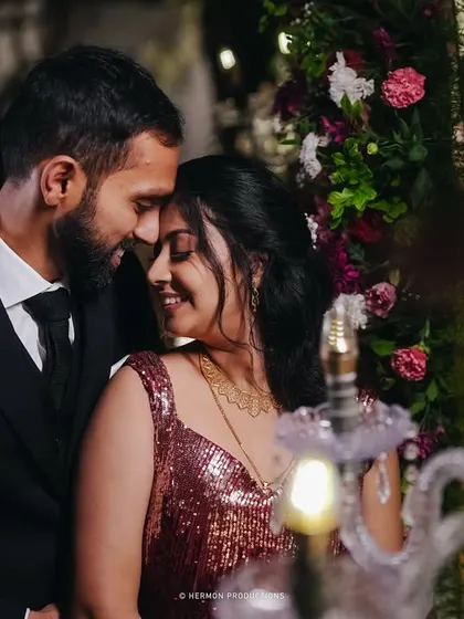 An intimate portrait of a couple at their reception, surrounded by flowers and soft lighting that enhances the romantic mood.