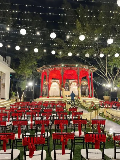 Another angle of the stunning red and white reception decor, showing the meticulous planning of the seating and stage.