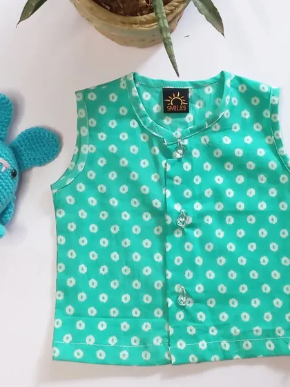 A sea green polka dot jhabla, perfect for adding a pop of color to your baby's wardrobe. The fabric is soft, breathable, and ideal for summer.