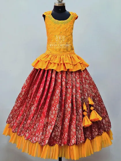 A layered gown in yellow and red. The skirt is a beautiful red brocade, and the top has modern ruffles.