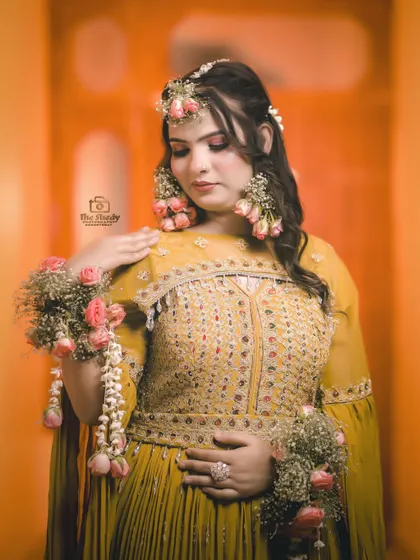 A beautiful close-up of Simran, highlighting the delicate floral jewelry on her hands and hair. These details make Haldi photos so special.