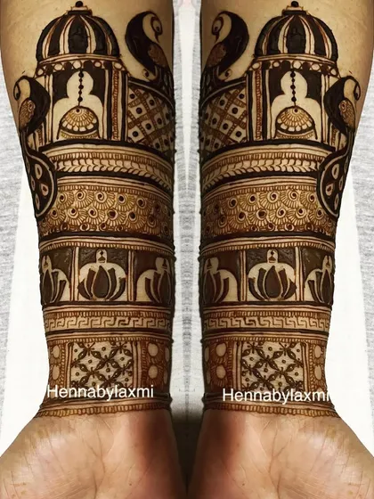 Symmetrical palace and peacock designs on the forearms. This architectural style of mehandi gives a very royal and grand appearance.
