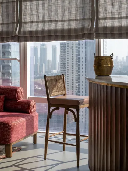 A bar corner in the 'Inde Blue' project, overlooking the Mumbai skyline. The design is calm and textural, with natural materials and soft, diffused light creating a space that invites you to exhale and enjoy the view.