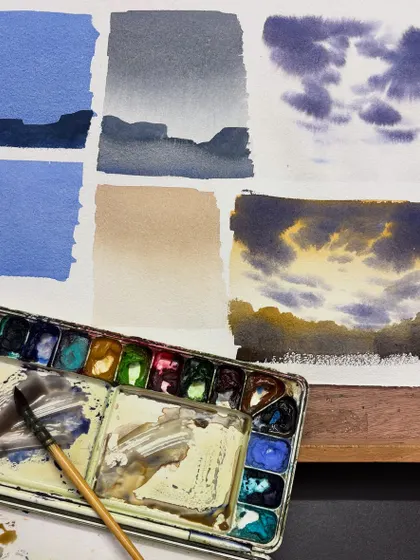 A practice sheet from an online class, showing different techniques for painting skies and clouds in watercolor.