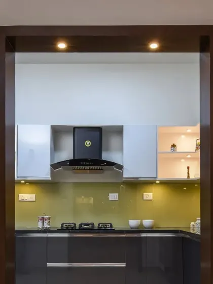 The view from the kitchen entrance, framed by a dark wood casing. This shot highlights the clean lines and modern appliances of the space.
