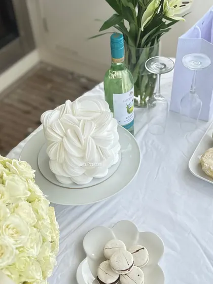 Another shot of the wafer paper cake at a celebration, paired with wine and macarons.