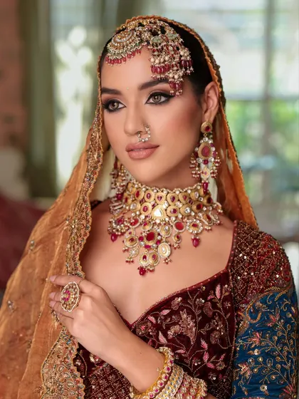 A stunning close-up with the dupatta framing the face. The kohl-rimmed eyes and perfectly sculpted features create a look of royal elegance.