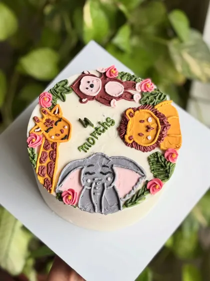 An overhead view of the jungle animal milestone cake, showing the cute arrangement of the piped characters.