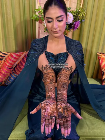 A happy bride showcasing her intricate portrait mehndi. The design features a couple on each palm, telling their unique love story.