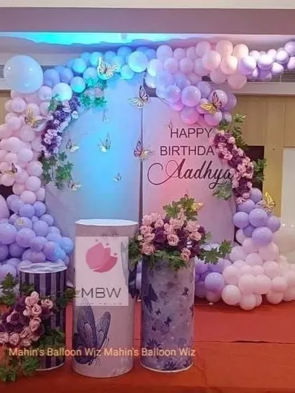 An elegant butterfly-themed party in shades of lavender and lilac. The design includes arched backdrops, floral arrangements, and custom-printed pedestals for a cohesive and beautiful look.