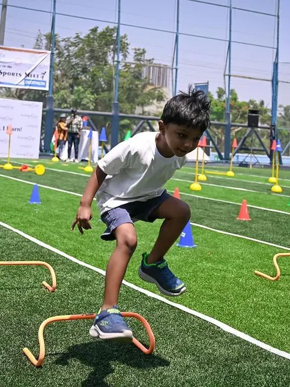 A boy leaps over a hurdle with great energy and enthusiasm.