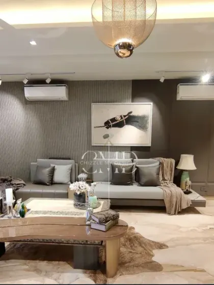 This view of the living and bar area in the Gurgaon home shows the seamless integration of entertainment and relaxation zones, unified by warm tones and sophisticated materials.