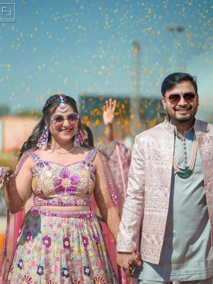 The pure, unadulterated joy of a wedding celebration. This shot captures the vibrant energy of a daytime Mehendi, with flower petals raining down on the happy couple. It’s about capturing the fun, the laughter, and the cool, modern vibe of your celebration.