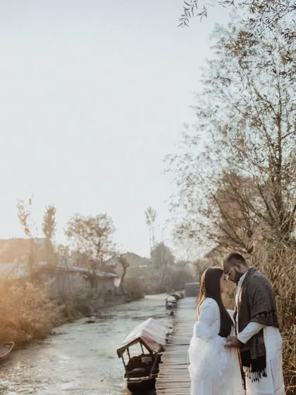A romantic silhouette of Ayushi and Vaibhav against the setting sun over the waterways of Kashmir, creating a serene and beautiful pre-wedding moment.