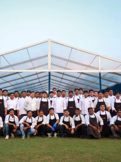 A group photo of the entire Zest team in front of an event marquee.