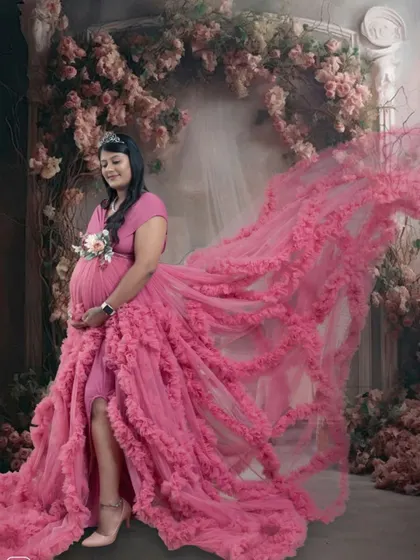 The flowing pink gown creates a stunning visual effect in this artistic shot, with the train beautifully arranged to look like it's flying.
