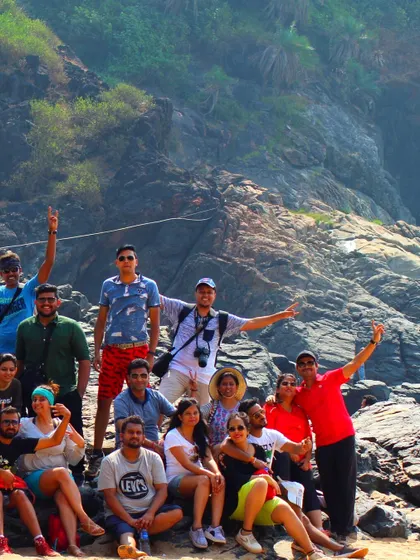 The team celebrating their successful Gokarna beach trek with a group photo against the rocky landscape.