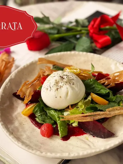 Creamy burrata served on a bed of greens with beetroot and crispy wafers. A perfect starter for a romantic meal.
