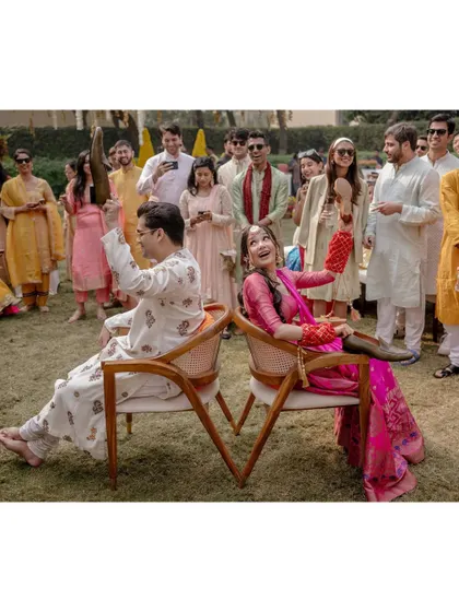 Saanya and Aayush play the shoe game during their mehendi, a fun and lighthearted way to see how well they know each other. Their laughter and the involvement of their guests make it a great moment.