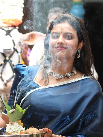 A candid shot of Sonu during a puja, the smoke from the incense creating a divine aura around her.