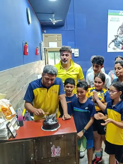 Coach Prafull cutting his birthday cake, surrounded by his students at the Willingdon Catholic Gymkhana center.