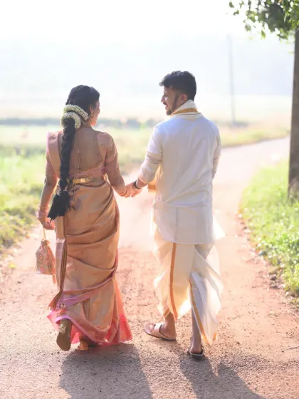 A follow-shot of the couple walking away, hand in hand. This perspective tells a story of their journey together, set against a beautiful, natural backdrop.