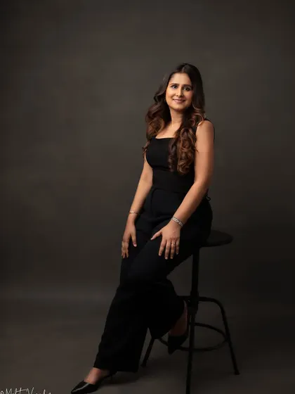 We used a classic dark backdrop for this full-length shot to create a powerful and elegant business portrait. The clean lines and confident pose make this a standout image for any professional profile.