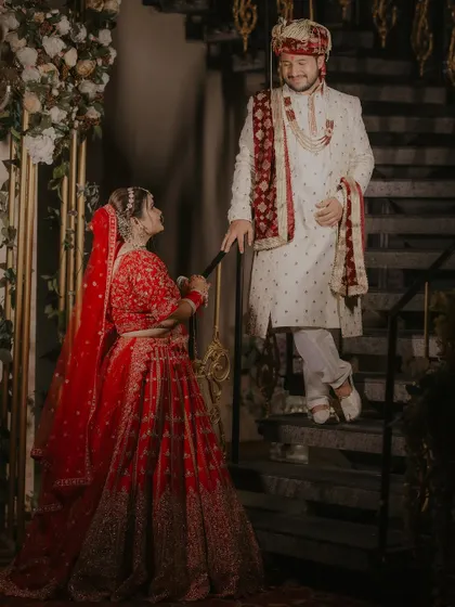 A playful and romantic portrait of the couple on a staircase, with the bride gently pulling the groom's stole.