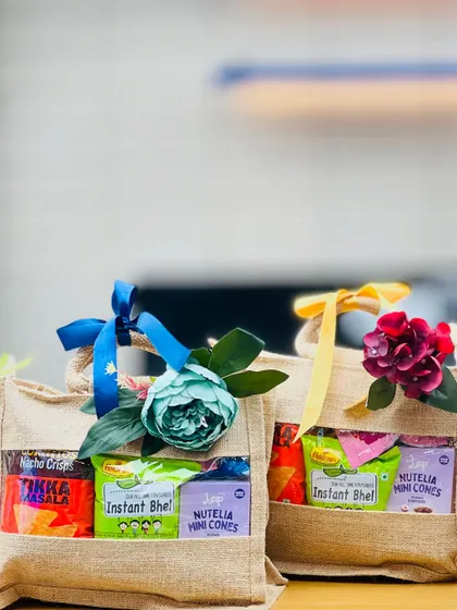 A close-up of two jute bag hampers, decorated with different colored flowers and ribbons to distinguish them.