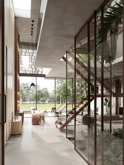 The entrance foyer of a Pavilion home is centered around a glass courtyard. This space opens onto an expansive living area with views of the paddy fields, and uses warm textures and minimal furniture to keep the focus on the landscape.