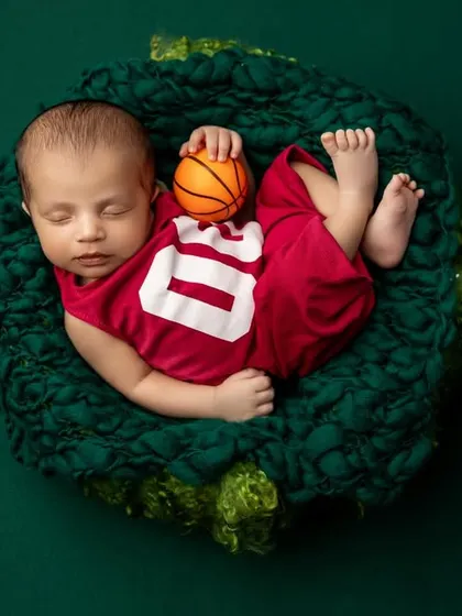 A perfect overhead shot of the basketball theme, capturing the vibrant colors and the adorable, sporty setup. These themed shoots are a great way to incorporate parents' hobbies.