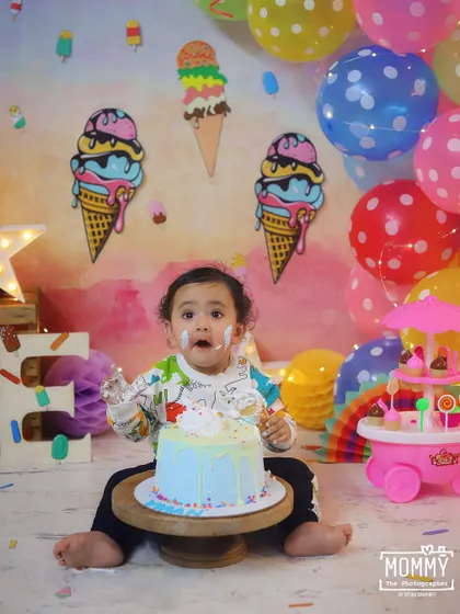 Caught in the act! This adorable shot captures the messy fun of a first birthday cake smash perfectly.