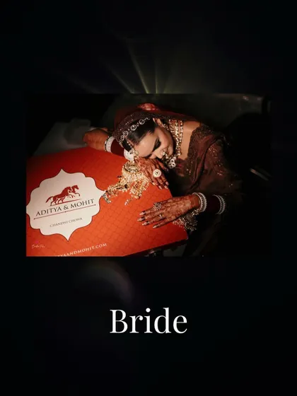 An emotional and artistic shot of the bride, resting her head on her wedding lehenga box, a moment of quiet reflection.