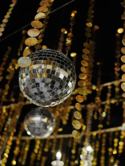 A close-up of the sangeet decor, with disco balls and cascading golden sequins hanging from the ceiling.