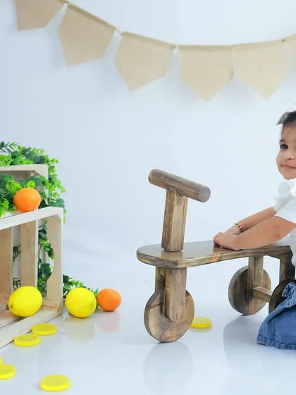 A simple and sweet toddler portrait. The clean white background, wooden props, and a pop of citrus color create a fresh and modern look.