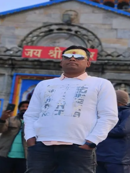 A close-up of a pilgrim with a tilak on his forehead, standing in front of the 'Jai Shri Kedar' entrance. This photo embodies the sense of fulfillment and peace after having darshan.
