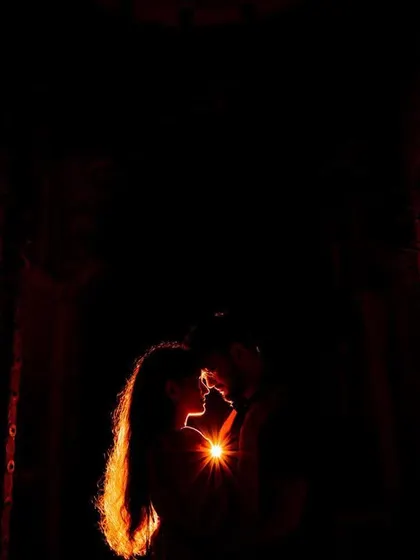 A dramatic silhouette shot against a textured, warmly lit door. We use creative lighting techniques to produce artistic and memorable pre-wedding images.