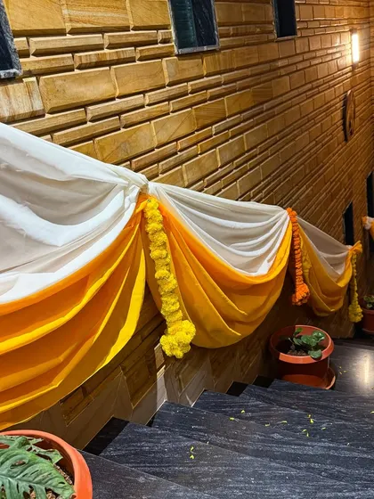 Even staircases get a festive makeover for a Haldi function. We used yellow and white drapes with marigold strings to decorate the railings.