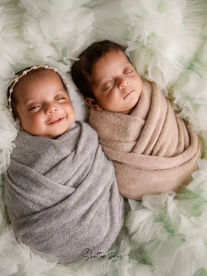 A joyful twin portrait, capturing a beautiful smile. Posing twins together on a soft, textured background creates a feeling of connection.