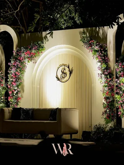 The stage for Saurabh and Shreya's engagement, featuring elegant white arches adorned with pink and white florals. This clean, romantic design provided a beautiful contrast to the dark, ambient lighting of the evening.