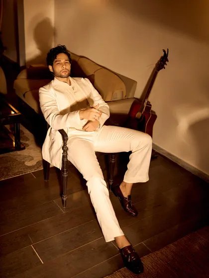 Another shot of Siddhant's all-white look, highlighting the relaxed fit and the subtle texture of the fabric. It’s a modern take on the classic suit.
