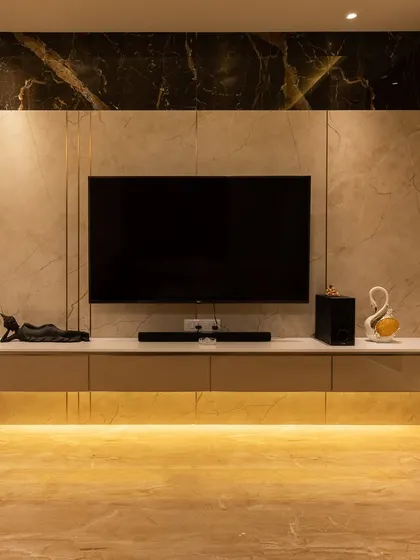 The entertainment area features a floating console with under-lighting and a dramatic black and beige marble-finish wall, creating a sophisticated focal point.
