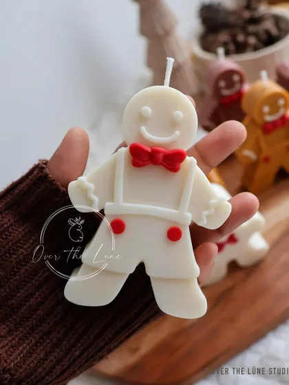 My hand-painted gingerbread man candle, complete with a smile and a bright red bow tie. He's almost too cute to light.
