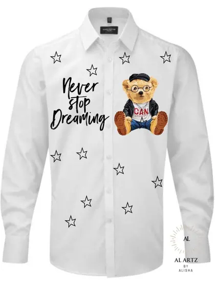 A cute and stylish hand-painted shirt featuring a well-dressed teddy bear and the phrase "Never Stop Dreaming." This design is perfect for adding a touch of playful charm to your wardrobe.