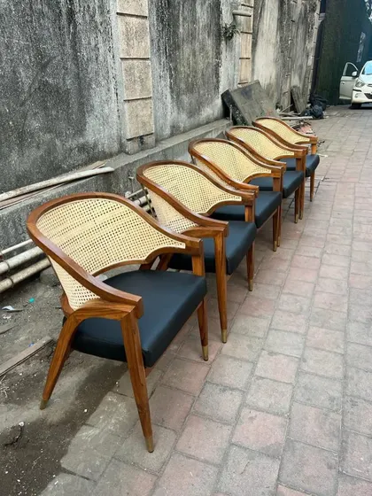 A side view of the line of five chairs, emphasizing their elegant, curved backrest.