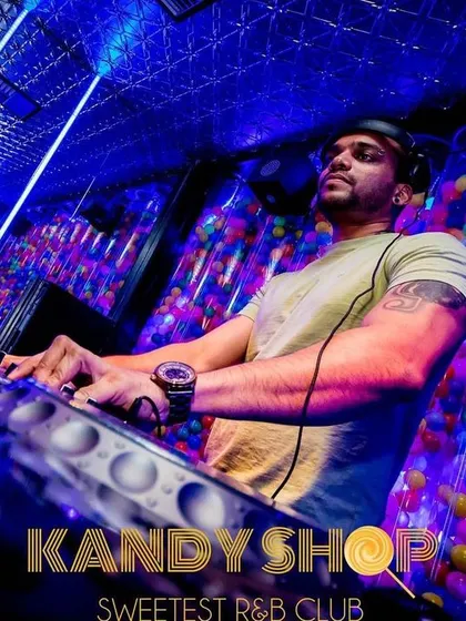 A low-angle shot of me at the Pioneer decks at Kandy Shop. The club's unique decor and lighting always make for a great visual experience.